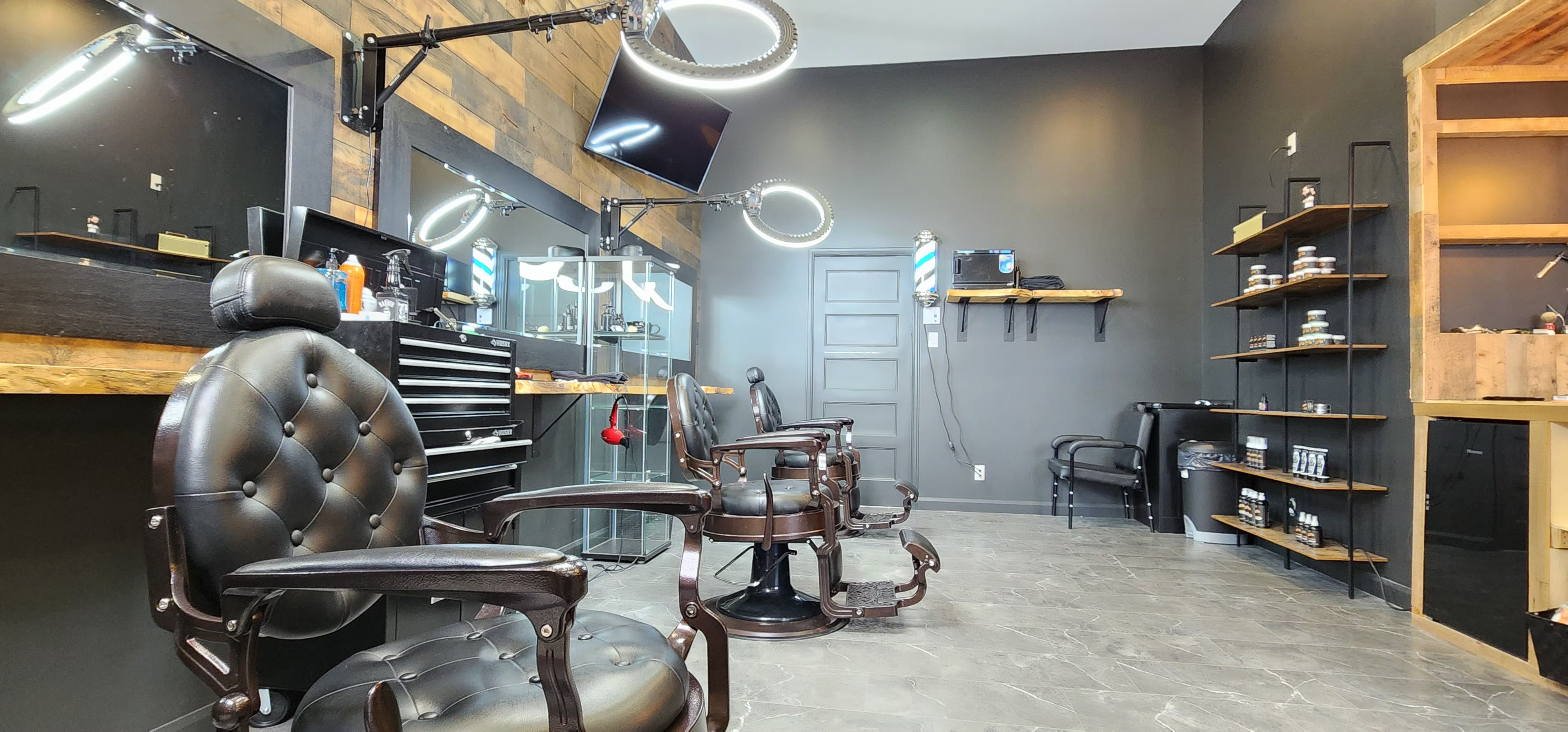 Vue de l'aménagement de la Habana Barbershop, fauteuils de barbier classiques.